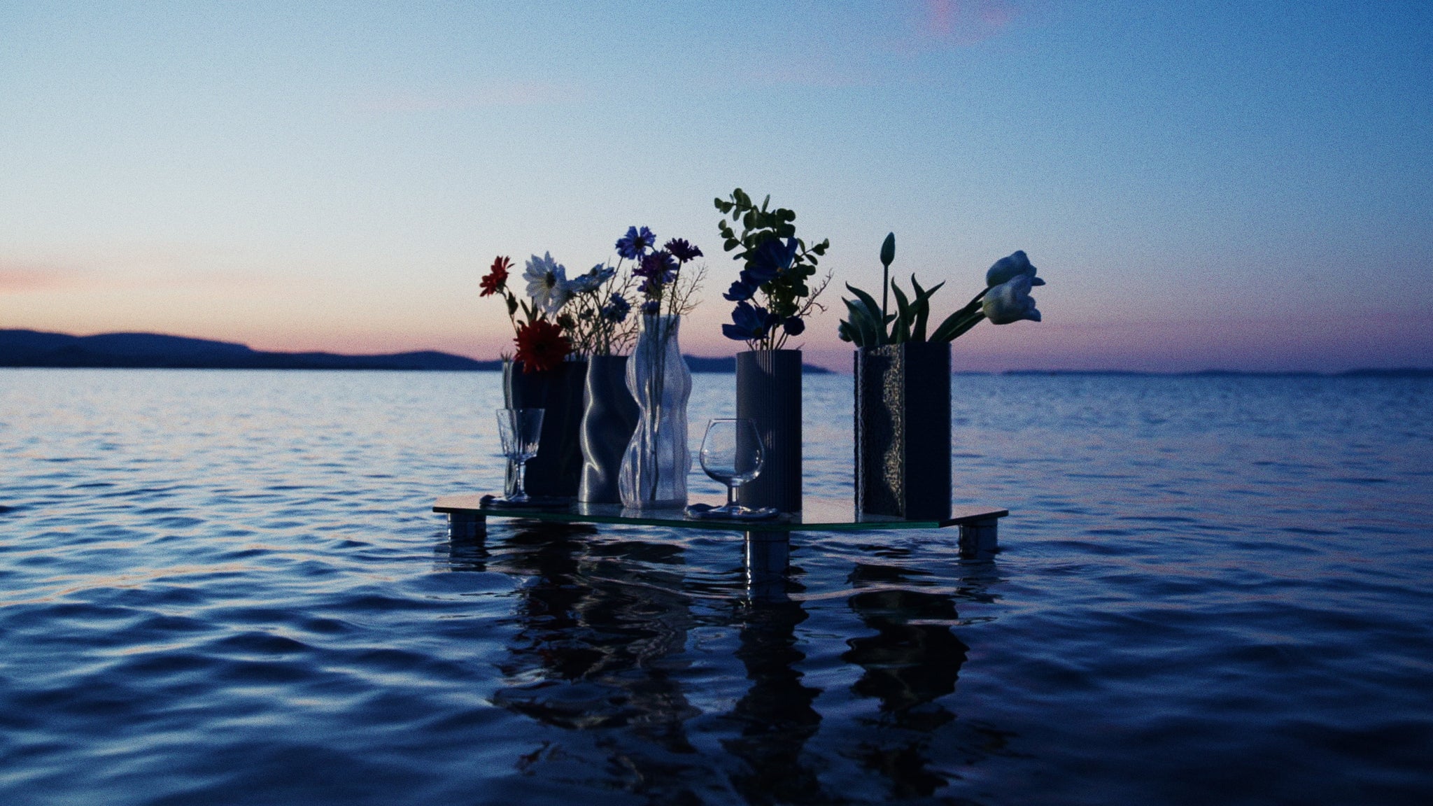 Présentation de la collection Chrome Core, les objets sont posés sur une table en pleine mer au lever du soleil