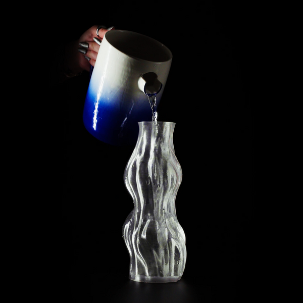 Vase Aria sur fond noir en train d'être rempli par un pichet