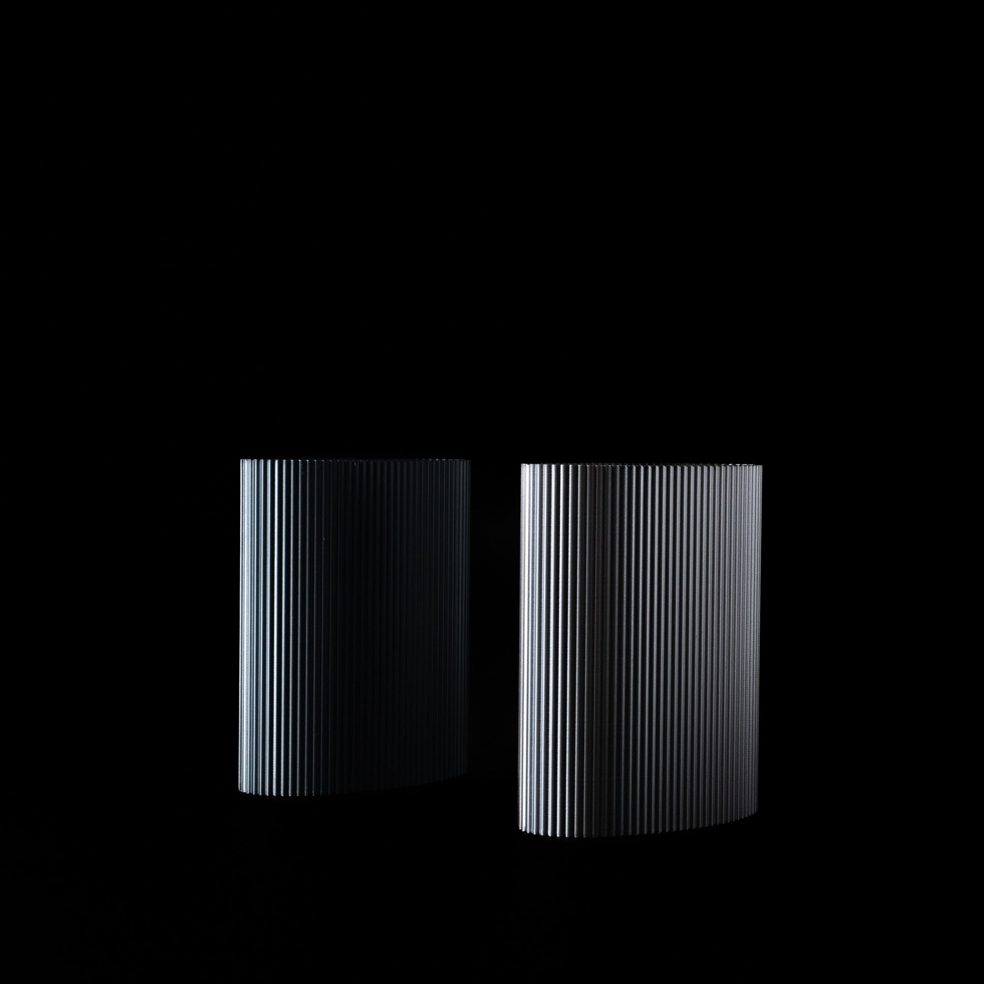 Deux vases Riga en PLA chromé, vides, photographiés en studio sur fond noir